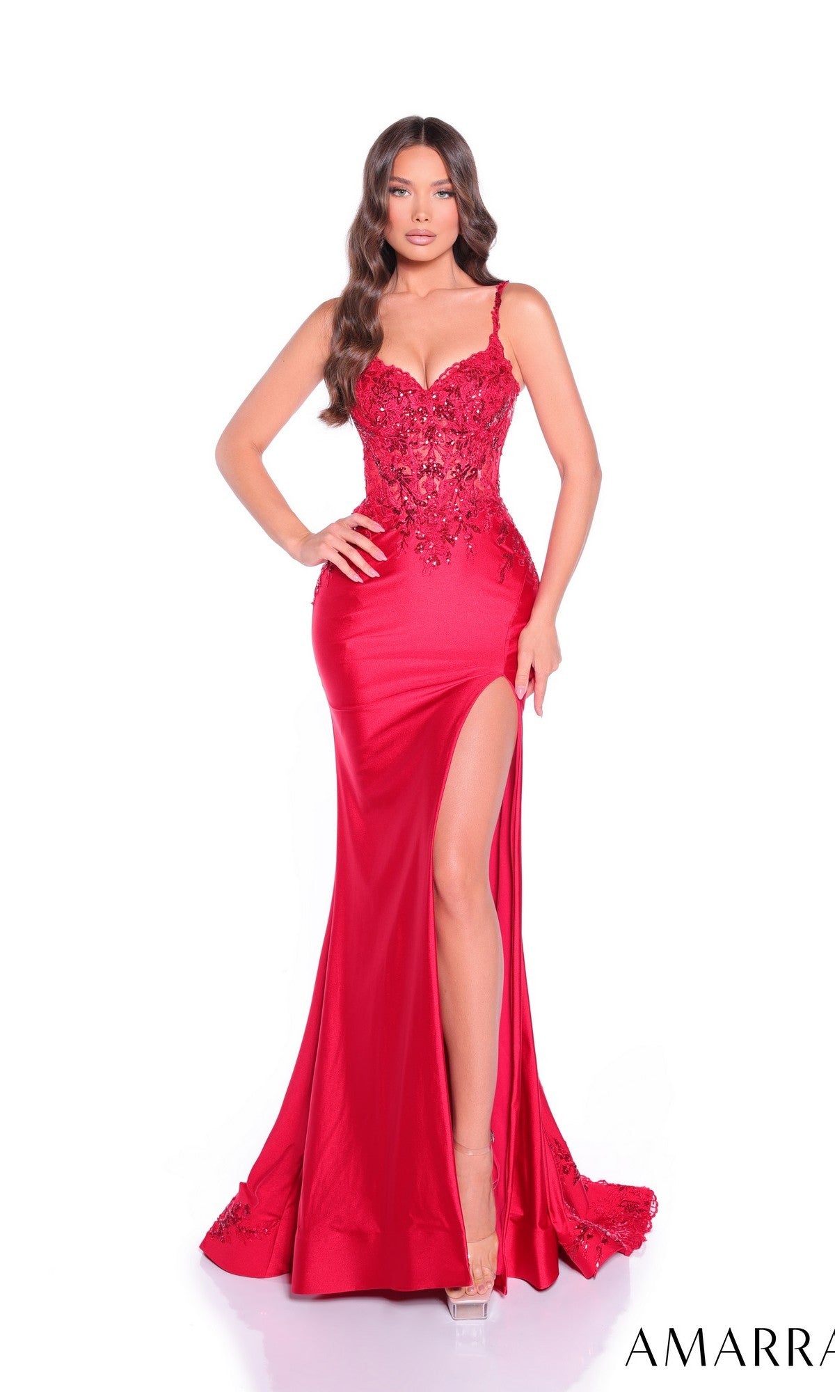 A woman poses against a white background wearing the Amarra 89449 long prom dress featuring a fitted, floor-length red design with lace details, spaghetti straps, and a high slit.